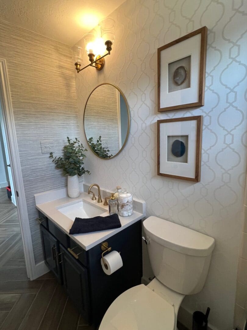 A bathroom with a toilet, sink and mirror.