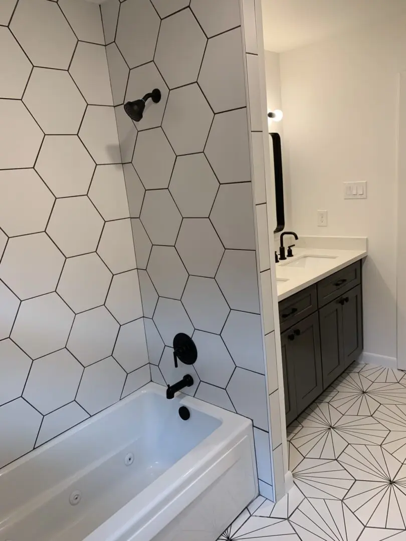 A bathroom with black and white hexagon tile.