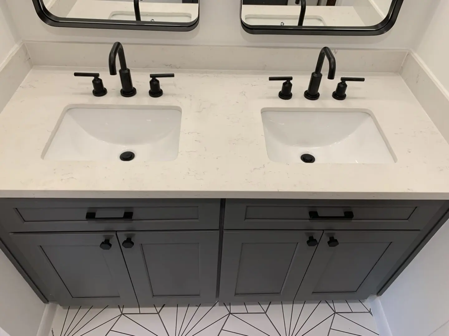 A bathroom with two sinks and mirrors.