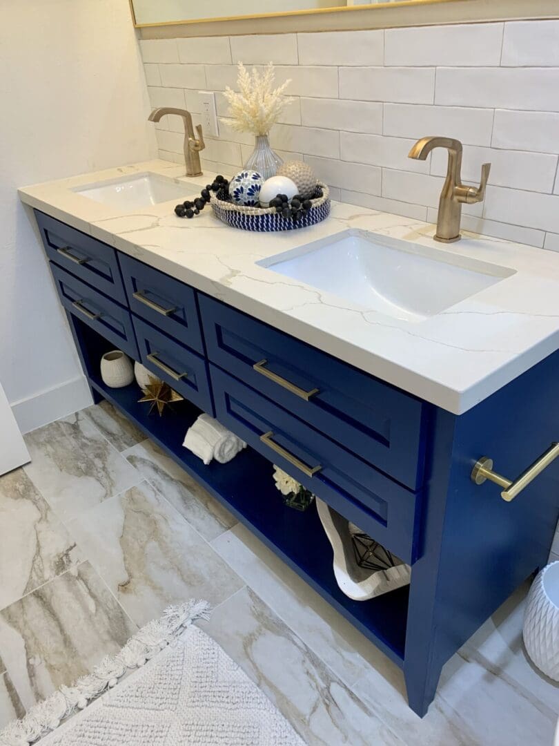 A blue bathroom vanity with gold hardware.