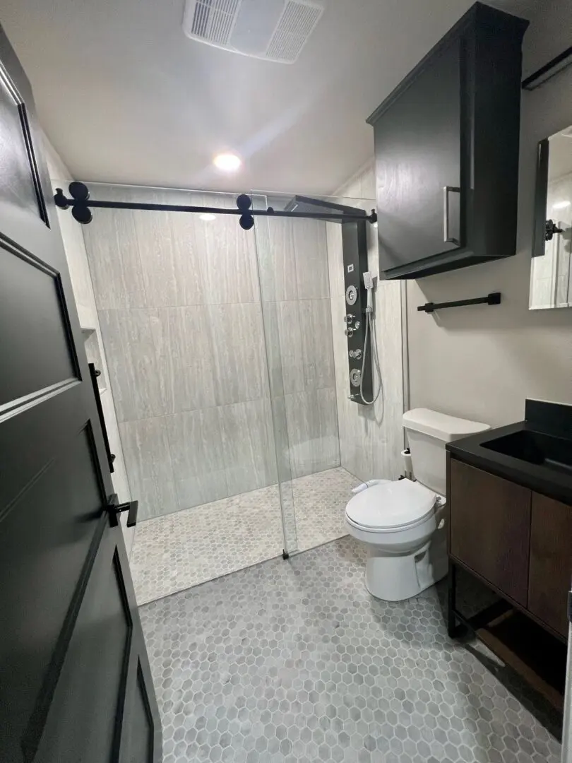 A bathroom with a toilet, sink and shower.